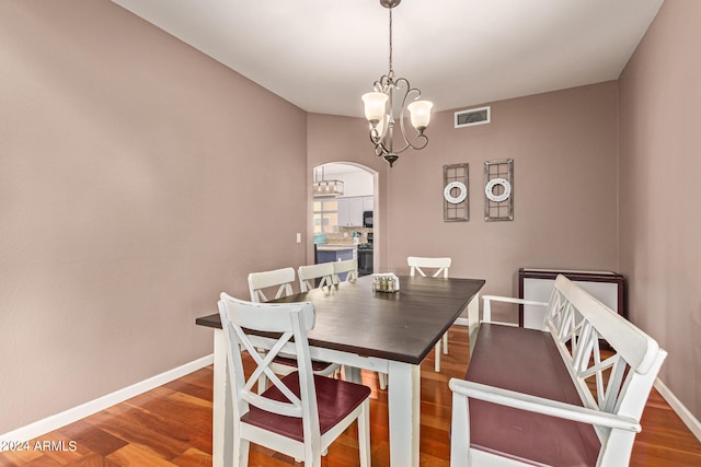 dining area featuring hardwood / wood-style floors and a notable chandelier