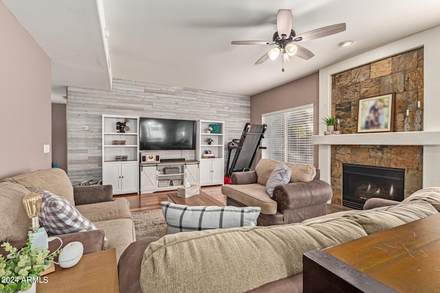 living room featuring hardwood / wood-style floors, ceiling fan, and a fireplace