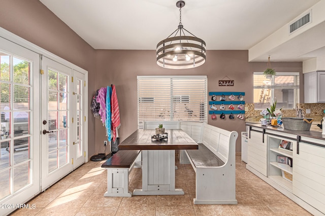 dining area with a notable chandelier and light tile patterned floors