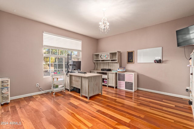 home office with hardwood / wood-style floors and an inviting chandelier