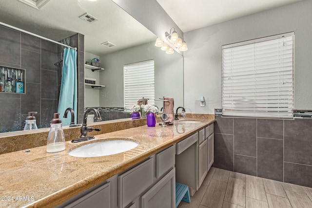 bathroom featuring curtained shower, tile walls, a textured ceiling, and vanity