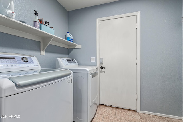 laundry room with light tile patterned floors and washing machine and clothes dryer