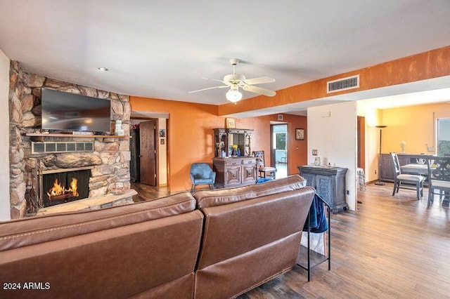 living room featuring wood-type flooring, a fireplace, and ceiling fan