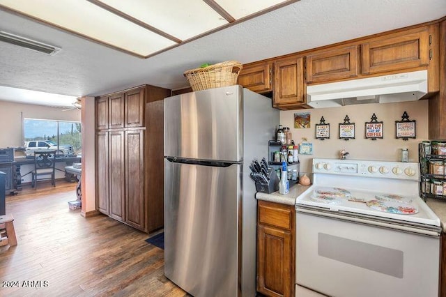 kitchen featuring wood-type flooring, a textured ceiling, white range with electric cooktop, and stainless steel fridge