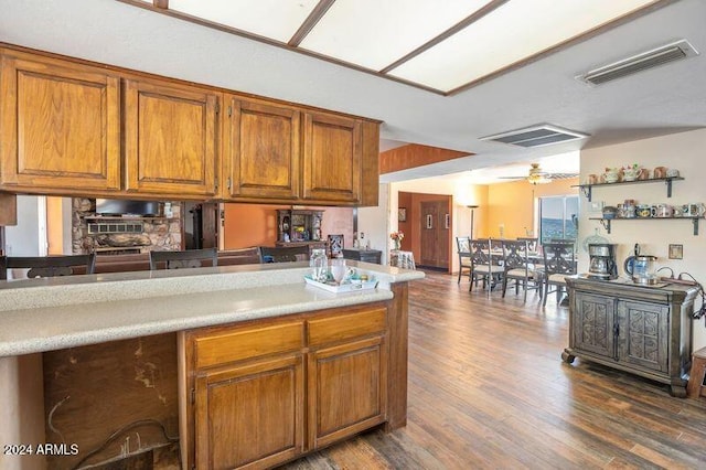 kitchen featuring kitchen peninsula, dark wood-type flooring, and ceiling fan