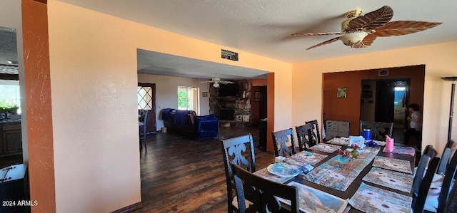 dining room featuring ceiling fan, a textured ceiling, and dark hardwood / wood-style flooring