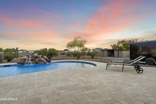 103 W Tanya Rd, Phoenix, AZ 85086 - pool at dusk featuring an outbuilding, a shed, an outdoor pool, and a patio area