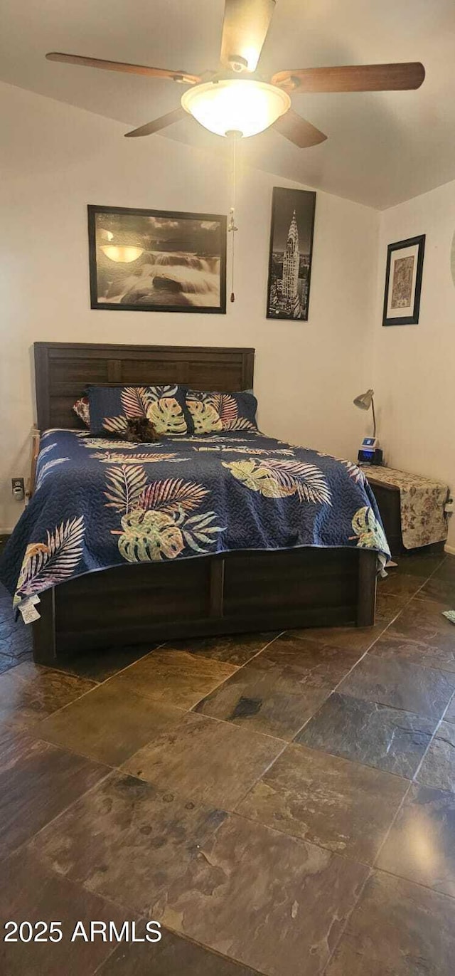 bedroom featuring a ceiling fan and stone finish flooring