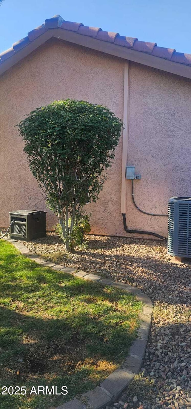 view of side of property with central AC and stucco siding
