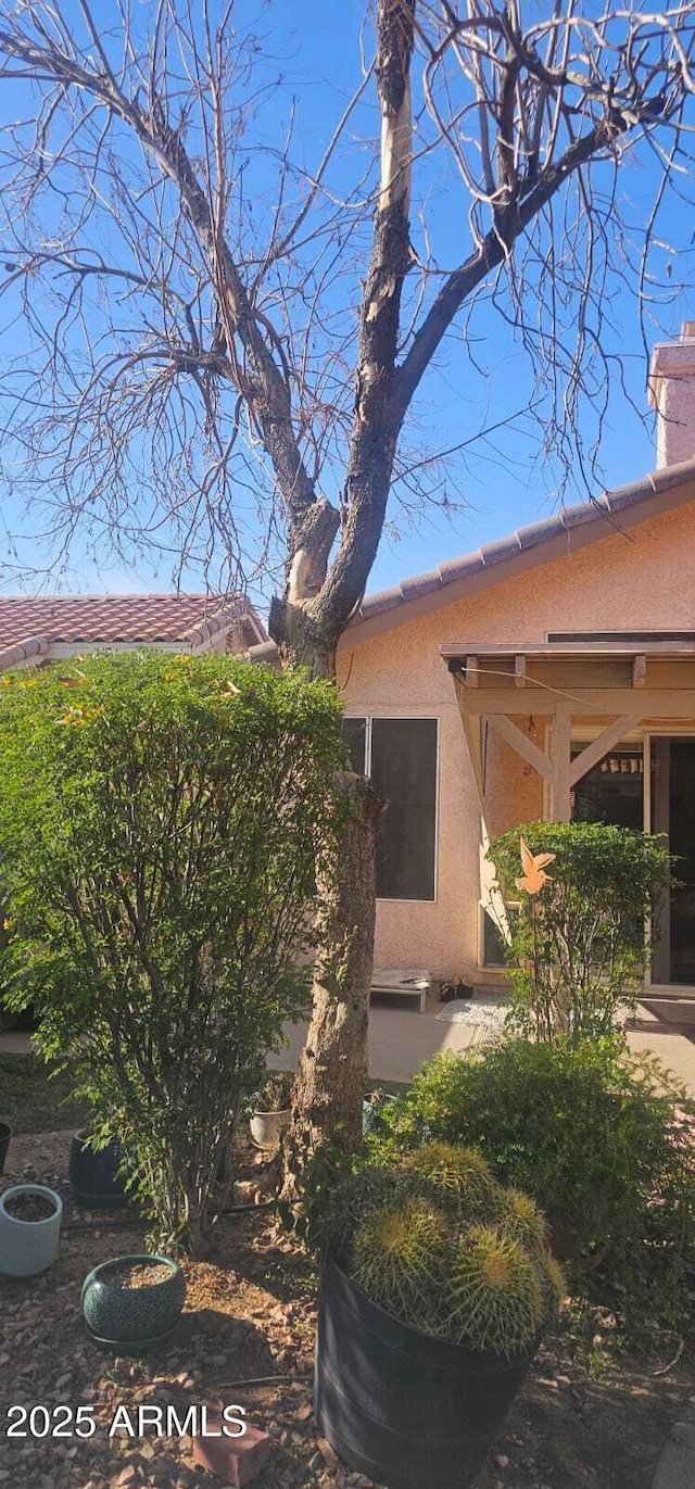 view of property exterior featuring stucco siding and a chimney