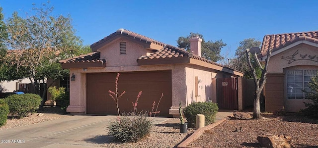 view of property exterior featuring a tile roof, a garage, stucco siding, a chimney, and concrete driveway