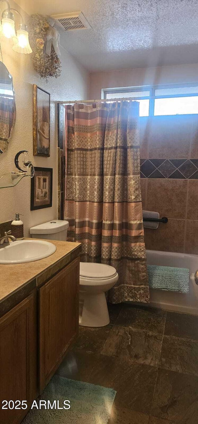 full bathroom featuring visible vents, a textured ceiling, toilet, and vanity