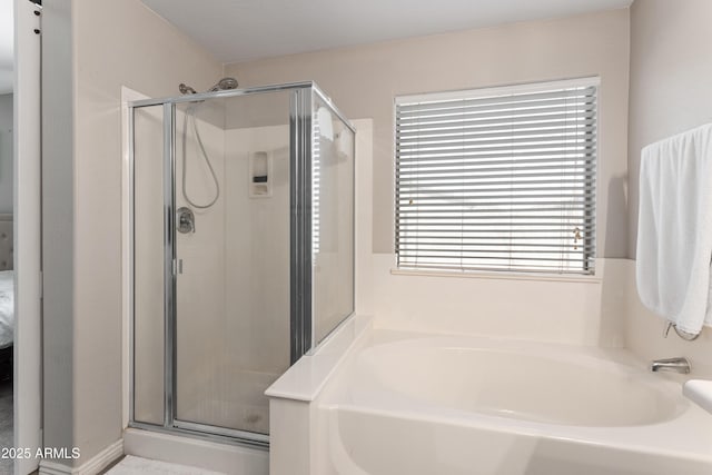 full bath featuring a stall shower and a garden tub