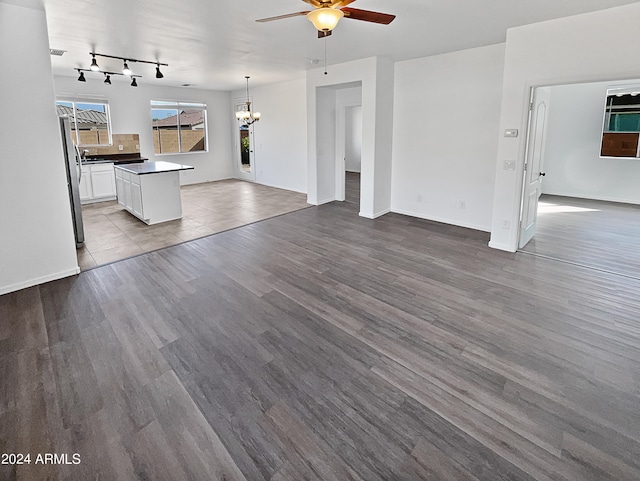 unfurnished living room featuring ceiling fan and hardwood / wood-style floors