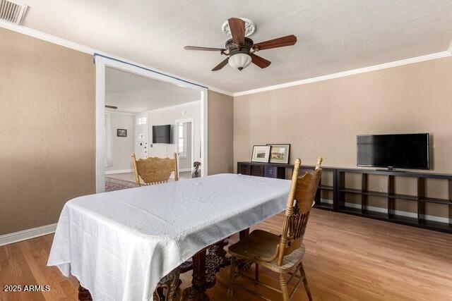 101 E Safford St, Tombstone, AZ 85638 - dining room with crown molding, a ceiling fan, visible vents, baseboards, and wood finished floors