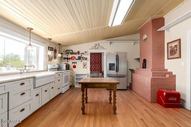 101 E Safford St, Tombstone, AZ 85638 - kitchen with a sink, stainless steel appliances, open shelves, light countertops, and hanging light fixtures