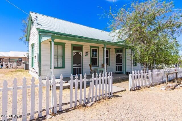 101 E Safford St, Tombstone, AZ 85638 - view of front facade with covered porch, a fenced front yard, and metal roof
