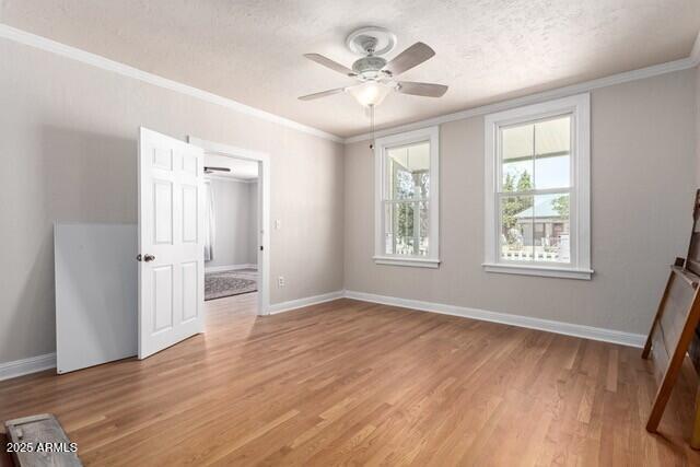 101 E Safford St, Tombstone, AZ 85638 - unfurnished bedroom with light wood-style floors, ceiling fan, baseboards, a textured ceiling, and crown molding