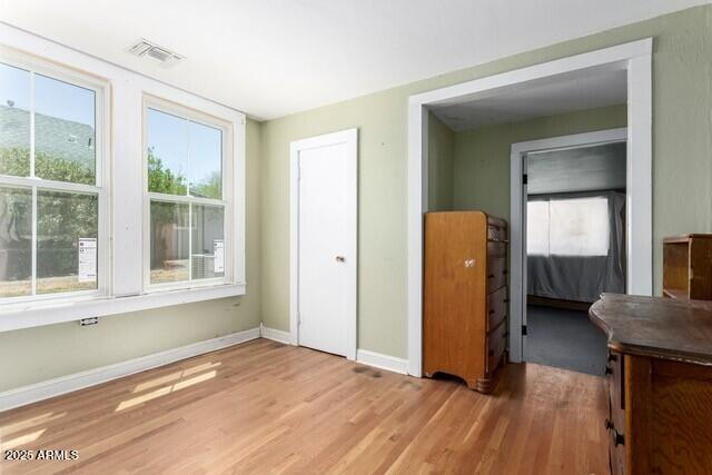 101 E Safford St, Tombstone, AZ 85638 - unfurnished bedroom featuring wood finished floors, visible vents, and baseboards