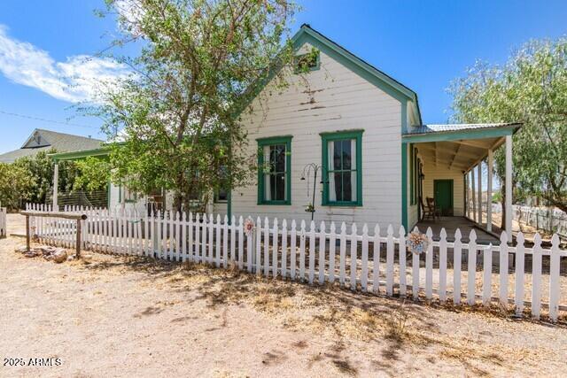 101 E Safford St, Tombstone, AZ 85638 - farmhouse-style home with a carport and a fenced front yard
