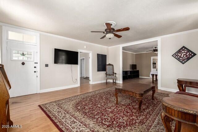 101 E Safford St, Tombstone, AZ 85638 - living room featuring wood finished floors, a ceiling fan, ornamental molding, and baseboards