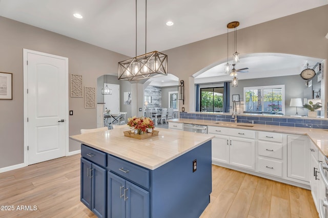 21266 S 213th Pl, Queen Creek, AZ 85142 - kitchen with arched walkways, stainless steel dishwasher, blue cabinetry, light wood-style floors, and recessed lighting