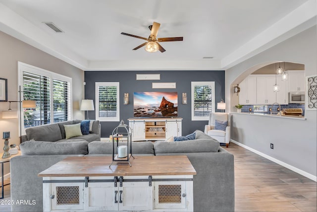 21266 S 213th Pl, Queen Creek, AZ 85142 - living area featuring ceiling fan, wood finished floors, plenty of natural light, and arched walkways