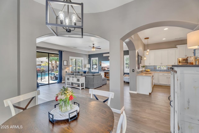 21266 S 213th Pl, Queen Creek, AZ 85142 - dining area featuring ceiling fan, arched walkways, light wood-style flooring, recessed lighting, and a chandelier