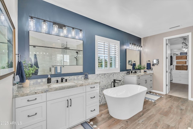 21266 S 213th Pl, Queen Creek, AZ 85142 - bathroom with a stall shower, two vanities, wood finished floors, and a freestanding bath