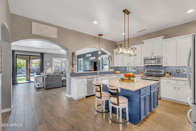 21266 S 213th Pl, Queen Creek, AZ 85142 - kitchen with appliances with stainless steel finishes, arched walkways, white cabinets, tasteful backsplash, and recessed lighting