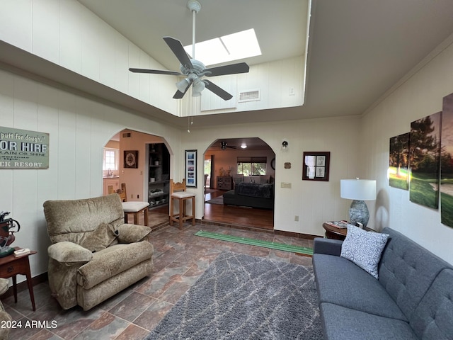 living room featuring crown molding, a high ceiling, a skylight, and ceiling fan