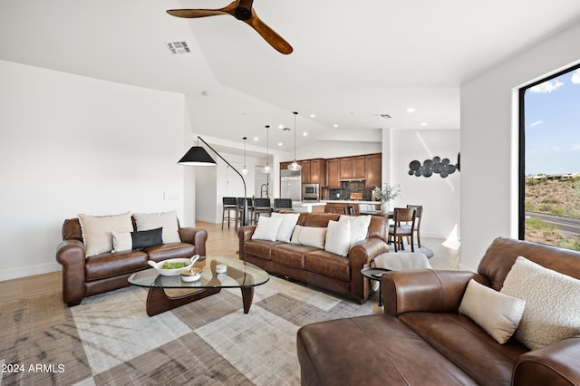 living room with lofted ceiling, light wood-type flooring, and ceiling fan