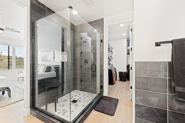 bathroom with a shower with shower door and hardwood / wood-style flooring