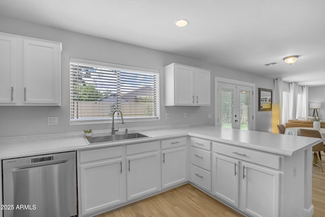 3349 E Flamingo Ct, Gilbert, AZ 85297 - kitchen with stainless steel dishwasher, a sink, a peninsula, white cabinetry, and plenty of natural light