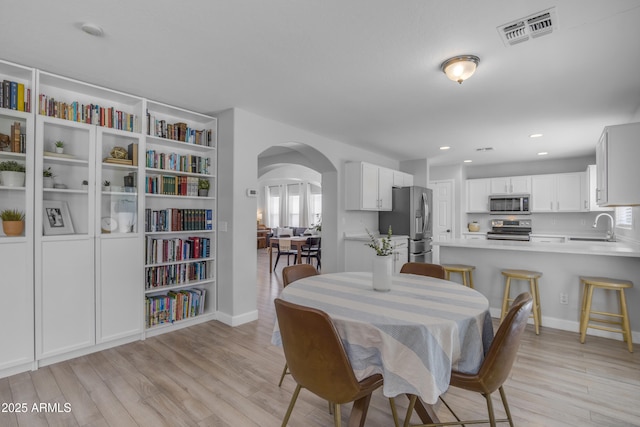 3349 E Flamingo Ct, Gilbert, AZ 85297 - dining room with arched walkways, light wood-style flooring, recessed lighting, and baseboards