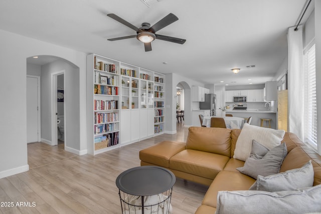 3349 E Flamingo Ct, Gilbert, AZ 85297 - living room with arched walkways, a ceiling fan, light wood finished floors, baseboards, and recessed lighting