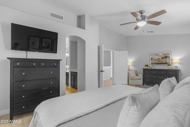 3349 E Flamingo Ct, Gilbert, AZ 85297 - bedroom featuring arched walkways, light wood finished floors, ensuite bath, baseboards, and ceiling fan