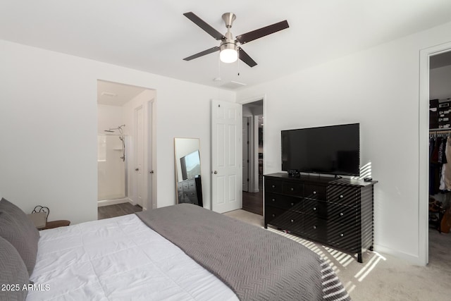 bedroom with ceiling fan, carpet flooring, connected bathroom, a spacious closet, and a closet