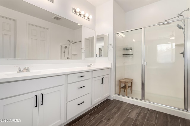 bathroom featuring vanity and a shower with door