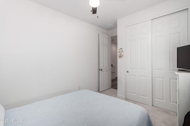 bedroom featuring ceiling fan, light colored carpet, and a closet