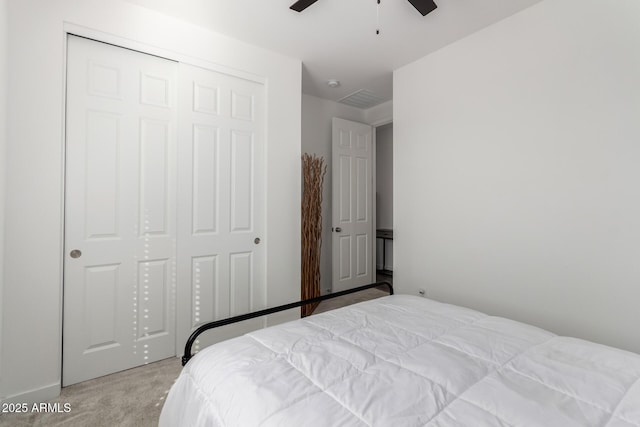 carpeted bedroom featuring ceiling fan and a closet