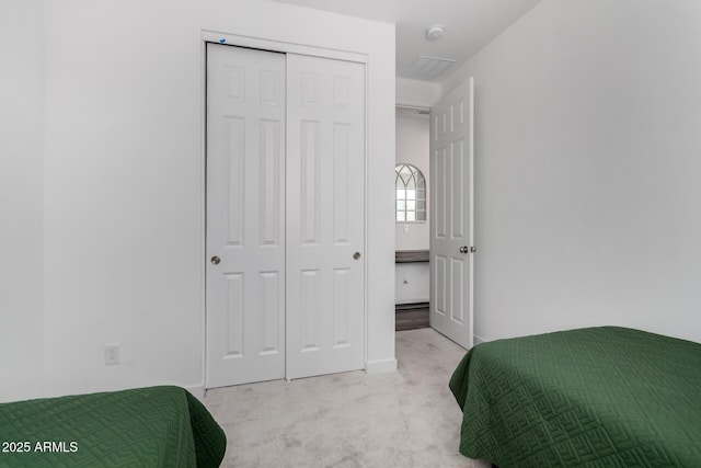 bedroom featuring light carpet and a closet