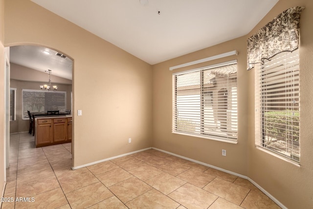 1347 E Vernoa St, San Tan Valley, AZ 85140 - spare room with baseboards, an inviting chandelier, arched walkways, vaulted ceiling, and light tile patterned floors