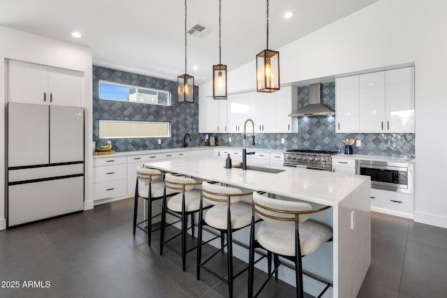 2225 E Whitton Ave E, Phoenix, AZ 85016 - kitchen featuring tasteful backsplash, wall chimney exhaust hood, a breakfast bar area, stainless steel appliances, and a sink
