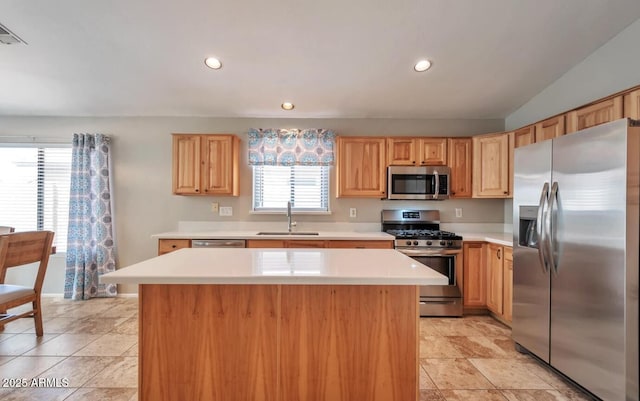 kitchen featuring stainless steel appliances, light countertops, a sink, and recessed lighting