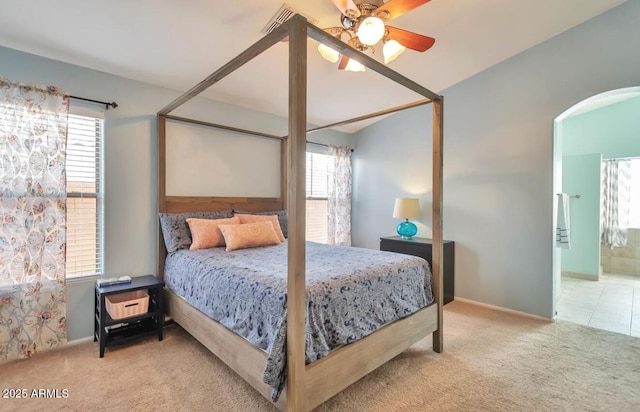 bedroom featuring arched walkways, carpet floors, baseboards, and multiple windows