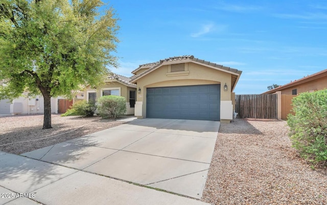 view of front of house with an attached garage, concrete driveway, fence, and stucco siding