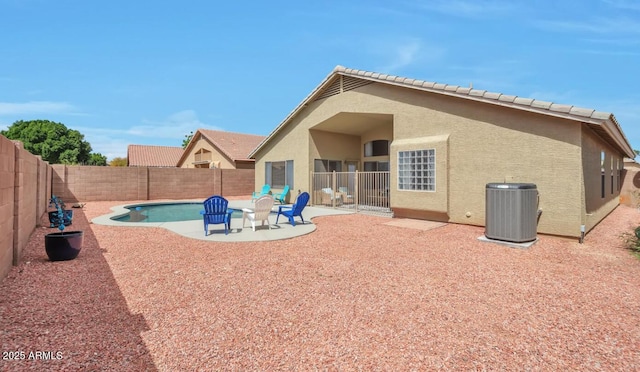 rear view of house with a tile roof, a fenced backyard, central air condition unit, a patio, and stucco siding
