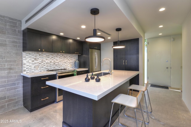 4411 N 40th St N Unit 37, Phoenix, AZ 85018 - kitchen with stainless steel appliances, concrete flooring, light countertops, a kitchen bar, and recessed lighting