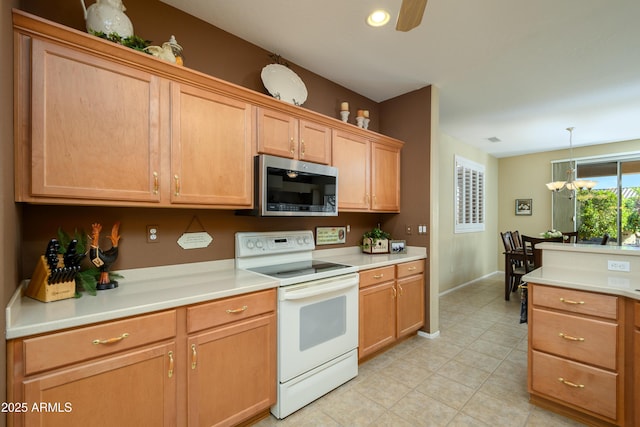 kitchen featuring white electric stove, ceiling fan with notable chandelier, and pendant lighting